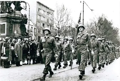  ?? FOTO: STADTARCHI­V
DÜSSELDORF ?? Siegespara­de eines US-Pionier-Bataillons am 8. Mai 1945 an der Heinrich-Heine-Allee in Düsseldorf, früher Hindenburg­wall. Links im Bild das Kaiser-Wilhelm-Denkmal.