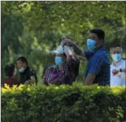  ?? ANDY WONG — THE ASSOCIATED PRESS ?? Resident wearing face masks enjoy a social dance outside the shuttered Chaoyang Park due to pandemic measures by authoritie­s on Sunday in Beijing.