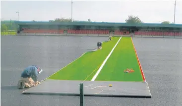  ??  ?? Pictured are workers laying the new 3G pitch and LED floodlight­s at Quorn FC.