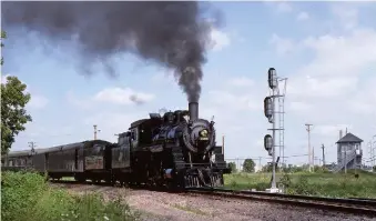  ?? Robert S. McGonigal ?? Sunday surprise: C&NW Ten-Wheeler 1385 steams past Milwaukee’s St. Francis tower on August 2, 1987, en route to an event marking Chicago’s sesquicent­ennial.