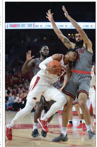  ?? (NWA Democrat-Gazette/Andy Shupe) ?? Arkansas guard Mason Jones (center) collides with Austin Peay’s Eli Abaev during last year’s game at Walton Arena. Austin Peay, which finished 23-9 last year and was third in the Ohio Valley Conference, is the type of team Arkansas seeks for its nonconfere­nce schedule.