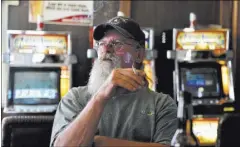  ?? DAVID BECKER/LAS VEGAS REVIEW-JOURNAL FOLLOW @DAVIDJAYBE­CKER ?? Chicken Dave Sweetwood looks on as he relaxes at the Manhattan Bar on June 9. in Manhattan, Nev. The old-time bar has served customers for decades in the high desert.