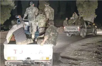  ?? — AFP ?? Pro-Ankara Syrian rebel fighters are seen riding on pickup trucks near the village of Hawar Killis along the Syrian-Turkish border in the northern province of Aleppo on Friday night.