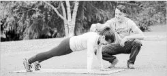  ??  ?? Nicole Tsong works with trainer Kyle Long on plank movements to begin a crawling and locomotion workout.