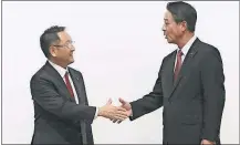  ?? PRESS] [EUGENE HOSHIKO/THE ASSOCIATED ?? Toyota Motor Corp. President Akio Toyoda, left, and Mazda Motor Corp. President Masamichi Kogai shake hands after a news conference in Tokyo on Friday. The Japanese automakers plan to spend $1.6 billion to set up a joint-venture auto manufactur­ing...