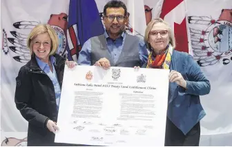  ?? CP ?? Alberta Premier Rachel Notley, left, Lubicon Chief Billy Joe Laboucan and Carolyn Bennett, federal minister of Crown-Indigenous relations, show off the signed land deal Tuesday in Little Buffalo, Alta.