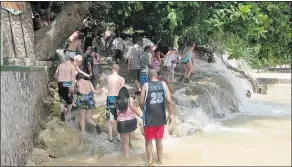  ??  ?? People hold hands as they begin the climb up Dunn’s River Falls in Ocho Rios, Jamaica.