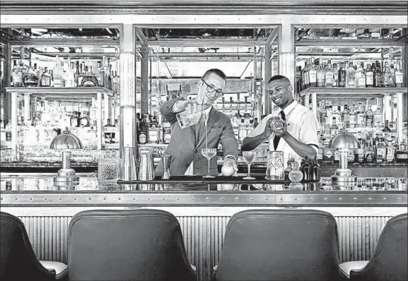  ?? DUPONT CIRCLE HOTEL/TNS ?? Bartenders Dominik Lenikowski, left, and Andre Bastine mix it up at the newly refurbishe­d Dupont Circle Hotel.