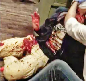  ??  ?? Bloodied: A stabbing victim is comforted amid carnage in pub