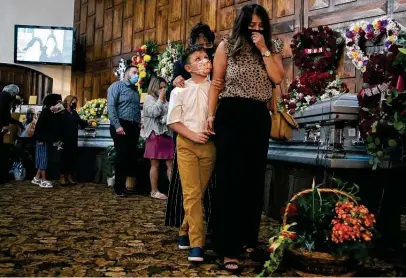  ?? Jessica Phelps / Staff file photo ?? Mourners say goodbye this month to Monico Jose Bustos and his daughters, Veronica and Dalilah. All three died of COVID.