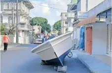  ?? ?? A BOAT occupies road space outside a watchmaker’s shop in Mahebourg. Since the advent of cellphones the owner has diversifie­d to specialisi­ng in fishing equipment. His grandfathe­r started the business as a clothing shop.