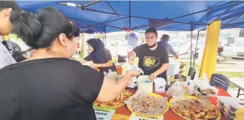  ?? ?? Aiman attends to customers at Suhaina’s stall.