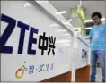 ?? CHINATOPIX VIA AP 2012 ?? A salesperso­n stands at counters selling mobile phones produced by ZTE Corp. at an appliance store in Wuhan in central China’s Hubei province.