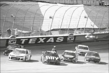  ?? ASSOCIATED PRESS ?? A NASCAR OFFICIAL CHECKS DRIVERS as the race was red flagged for over 11 minutes due to an 11-car incident during a NASCAR Cup Series auto race at Texas Motor Speedway in Fort Worth, Texas, Sunday.