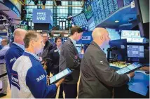  ?? COURTNEY CROW/NEW YORK STOCK EXCHANGE VIA AP ?? In this photo provided by the New York Stock Exchange, traders gather at a post on the floor Friday in New York. Stocks rose in morning trading on Wall Street on Friday, keeping the market on track for its first weekly gain after seven weeks of losses.