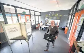  ?? Ben Birchall ?? > A ballot box is carried inside the Grange Pavilion bowling club, serving as a polling station in Grangetown, Cardiff