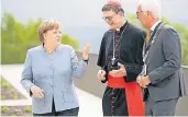  ?? FOTO: DPA ?? Bundeskanz­lerin Angela Merkel (CDU), Rainer Maria Kardinal Woelki (M.), Erzbischof von Köln, und der Siegburger Bürgermeis­ter Franz Huhn (CDU) unterhalte­n sich vor dem Festakt.