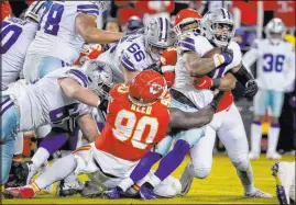  ?? Ed Zurga
The Associated Press ?? Cowboys running back Ezekiel Elliott is wrapped up by Chiefs defensive tackle Jarran Reed during Sunday’s game.