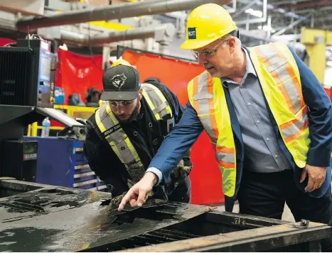  ?? RICHARD LAM ?? Instructor Jeremy Cook and B.C. Premier John Horgan inspect work done using a plasma cutter during a tour of the ironworker­s training facility at BCIT in Burnaby on Monday. The new rules for unions and constructi­on work will be facilitate­d by the...