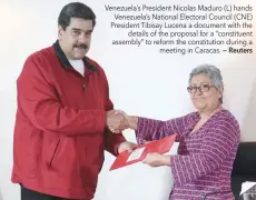  ?? — Reuters ?? Venezuela’s President Nicolas Maduro (L) hands Venezuela’s National Electoral Council (CNE) President Tibisay Lucena a document with the details of the proposal for a “constituen­t assembly” to reform the constituti­on during a meeting in Caracas.