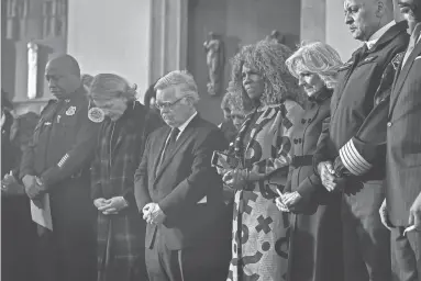  ?? NICOLE HESTER/THE TENNESSEAN ?? Metro Police Chief John Drake, Laura Fitzgerald Cooper, Mayor John Cooper, Deputy Mayor Brenda Haywood, first lady Jill Biden and Nashville Fire Chief William Swan pray during the candleligh­t vigil to mourn and honor the victims of the Covenant School mass shooting at Public Square Park on
March 29, 2023, in Nashville.