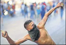  ?? REUTERS ?? A demonstrat­or throws a rock during an anti-government protest on Monday following last week’s deadly blast in Beirut.