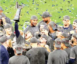  ?? (AP) ?? Houston Astros shortstop Carlos Correa hoists the American League championsh­ip trophy into the air after Game 7 of the ALCS against the New York Yankees in Houston.