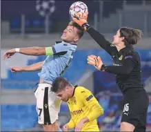  ?? REUTERS ?? Lazio’s Ciro Immobile rises to meet a cross as Borussia Dortmund goalkeeper Marwin Hitz defends during Tuesday’s UEFA Champions League Group F match at Stadio Olimpico in Rome. Immobile scored one goal and set up another in a 3-1 Lazio win.