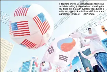  ??  ?? File photo shows South Korean conservati­ve activists rolling a large balloon showing the US flags by a South Korean flag during a rally to support South Korea-US free trade agreement in Seoul. — AFP photo