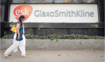  ?? — Reuters ?? A woman walks past a Glaxosmith­kline Pharmaceut­icals Ltd logo outside their headquarte­rs in Mumbai.