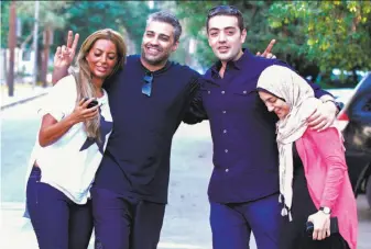  ?? AFP / Getty Images ?? Mohamed Fahmy (second from left) and his wife, Marwa Omara (left), and Baher Mohammed and his wife, Jihan, celebrate in Cairo after the men were released from prison.