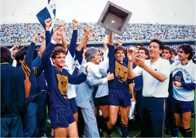  ??  ?? ORGULLOSO. Miguel España levanta el trofeo de Campeón de la Temporada 1990-1991 rodeado de sus compañeros.