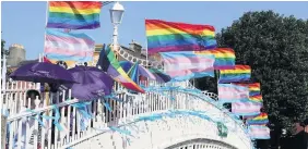  ??  ?? LGBT protesters from Dublin Pride and We Are Church with flags and umbrellas on Ha’Penny Bridge, Dublin, to remember the victims of clerical sex abuse