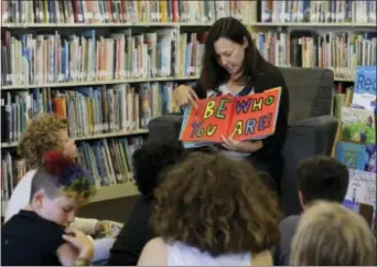  ?? JEFF CHIU — THE ASSOCIATED PRESS ?? Sandra Collins, executive director and founder of enGender, reads a book to campers at the Bay Area Rainbow Day Camp in El Cerrito Collins says, “A lot of these kids have been bullied and had trauma at school. This is a world where none of that exists, and they’re in the majority. That’s a new experience for kids who are used to hiding and feeling small.”