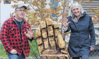  ?? JOE GIBBONS/THE TELEGRAM ?? Wood carver Bill Guiney and Joanne Thompson, executive director of The Gathering Place stand with “The Helping Hand,” one of two chainsaw artworks Guiney created as gifts for the facility. It took Guiney two days to carve “The Helping Hand” and “The Healing Tree.”
