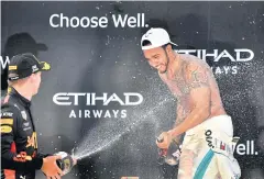  ?? AFP ?? Lewis Hamilton, right, celebrates on the podium with Max Verstappen in Abu Dhabi.