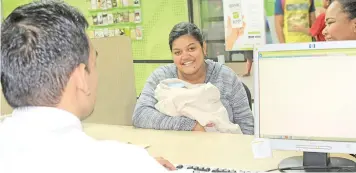  ?? Photo: Bank South Pacific ?? Vaciseva Petersen getting her baby Mathias Zephanaia Petersen’s account opened at BSP through the Government’s Parenthood Assistance Payment Programme.