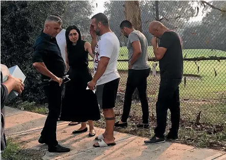  ?? NINE ?? Danny Abdallah (centre) is comforted yesterday morning at the scene of the collision in Oatlands.