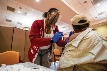  ?? ALYSSA POINTER/ALYSSA.POINTER@AJC.COM ?? Dekalb County Board of Health worker Lisa Bridges administer­s a COVID-19 vaccinatio­n during a joint event last month with Delta Sigma Theta Sorority Inc. at Lou Walker Senior Center in Stonecrest.