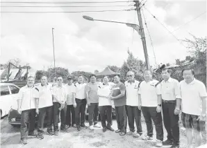 ?? ?? PRIHATIN: Lau (tujuh kiri) menyampaik­an sumbangan bantuan kepada salah seorang mangsa kebakaran di Kampung Bahagia Jaya Teku, semalam.