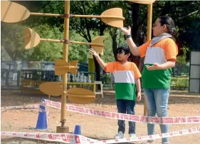  ?? — DC ?? Children wearing Tricolour dress seen playing at Sanjeevaia­h Park where they came to see the tallest National Flag, in Hyderabad on Tuesday.