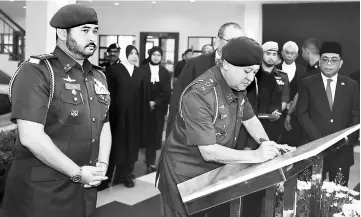  ??  ?? Sultan Ibrahim signs a plaque during the launching of the Muar Court Complex. Looking on are Tunku Ismail (left) and Mohamed Khaled (right). — Bernama photo