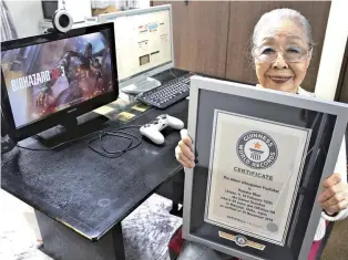  ?? Courtesy of Keisuke Nagao ?? Hamako Mori shows a certificat­e from Guinness World Records that recognizes her as the oldest gaming YouTuber.