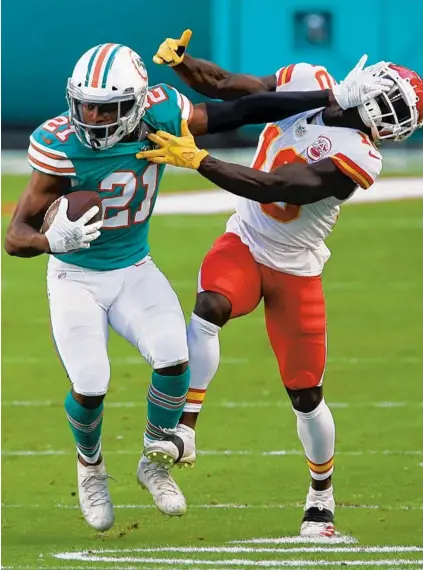  ?? JOHN MCCALL/SOUTH FLORIDA SUN SENTINEL ?? Dolphins safety Eric Rowe stiff-arms Kansas City Chiefs wide receiver Tyreek Hill after intercepti­ng a pass in December at Hard Rock Stadium in Miami Gardens.