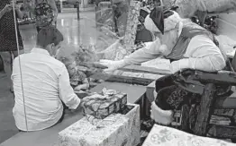  ?? LYNNE SLADKY/AP ?? A barrier keeps Federica Rodriguez from sitting on Santa’s lap Nov. 20 in Miami.