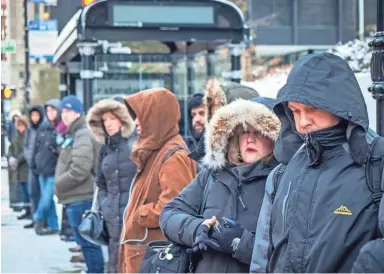  ?? RICH HEIN/CHICAGO-SUN TIMES ?? Commuters wait for buses Tuesday outside Union Station in Chicago. Record low temperatur­es were possible in the Great Lakes region, the Plains, Midwest and Northeast this week.
