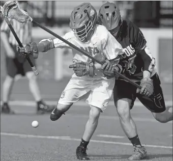  ?? TIM MARTIN/THE DAY ?? Norwich Free Academy’s Micah Tarlton, left, battles Fitch’s Christian Cloutier for a loose ball during the first half of Thursday’s Eastern Connecticu­t Conference Division I game in Norwich. The Wildcats prevailed in sudden death overtime, 11-10.