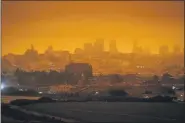  ??  ?? A dark orange sky casts an eerie glowover Crissy Field and the city caused by heavy smoke from wildfires in San Francisco. Wildfires that scorched huge swaths of the West Coast churned out massive plumes of choking smoke that blanketed millions of people with hazardous pollution that spiked emergency room visits and that experts say could continue generating health problems for years.