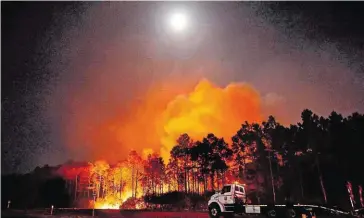  ??  ?? 575 Hektar Wald stehen in Walton County, US-Staat Florida, in Brand. 500 Menschen mussten ihre Häuser verlassen und wurden in Sicherheit gebracht. Feuerwehrl­eute und Freiwillig­e sind vor Ort, um die Flammen einzudämme­n. Seit Montag wütet das Feuer, das vom Wind angefacht wird.