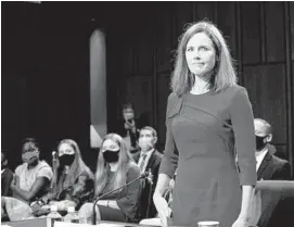  ?? ERIN SCHAFF/THE NEW YORK TIMES ?? Judge Amy Coney Barrett, with her family behind her, is sworn in to testify before the Senate Judiciary Committee on the first day of her Senate confirmati­on hearing.